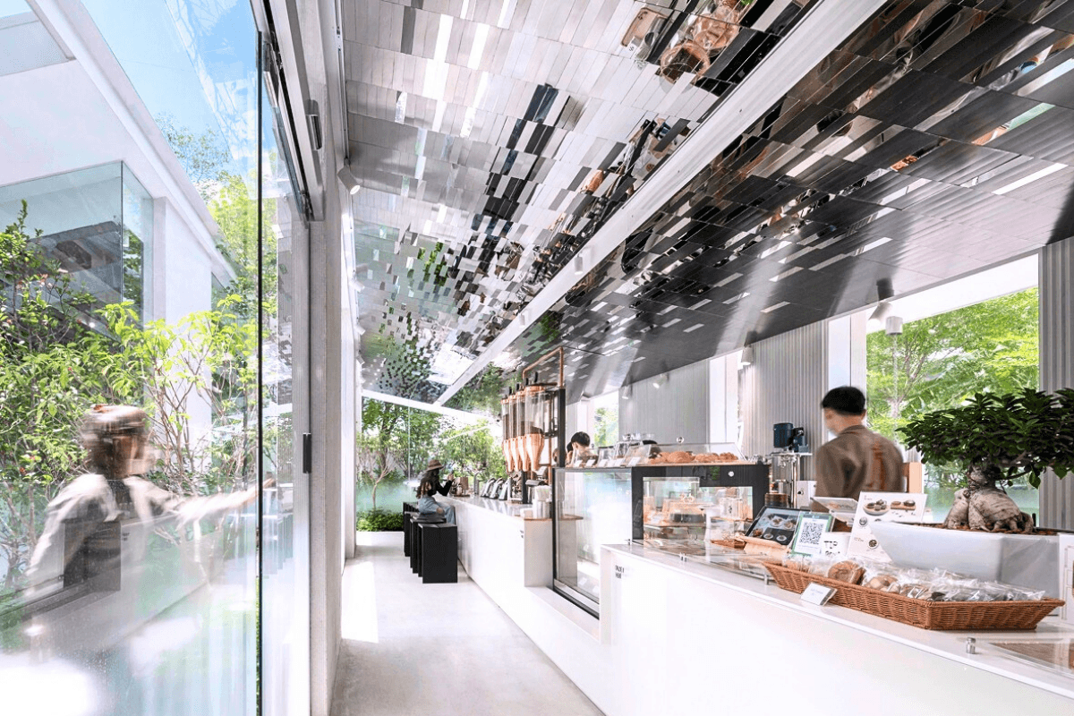 Кофейня «Nana Coffee Roasters», спроектированная бюроIDIN Architects, расположена в густонаселенном районе Бангна, Бангкок. Её основная цель — не ошеломить посетителя, а перенести его из городской суеты в спокойное и гармоничное пространство, где в центре внимания оказываются природа и сам кофе. Кофейня «Nana Coffee Roasters», спроектированная бюроIDIN Architects, расположена в густонаселенном районе Бангна, Бангкок. Её основная цель — не ошеломить посетителя, а перенести его из городской суеты в спокойное и гармоничное пространство, где в центре внимания оказываются природа и сам кофе.