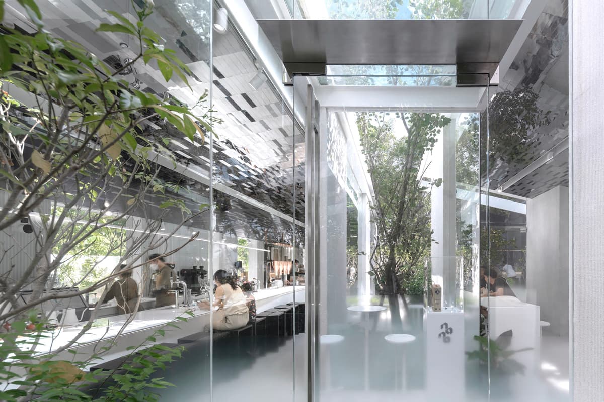 Кофейня «Nana Coffee Roasters», спроектированная бюроIDIN Architects, расположена в густонаселенном районе Бангна, Бангкок. Её основная цель — не ошеломить посетителя, а перенести его из городской суеты в спокойное и гармоничное пространство, где в центре внимания оказываются природа и сам кофе. Кофейня «Nana Coffee Roasters», спроектированная бюроIDIN Architects, расположена в густонаселенном районе Бангна, Бангкок. Её основная цель — не ошеломить посетителя, а перенести его из городской суеты в спокойное и гармоничное пространство, где в центре внимания оказываются природа и сам кофе.