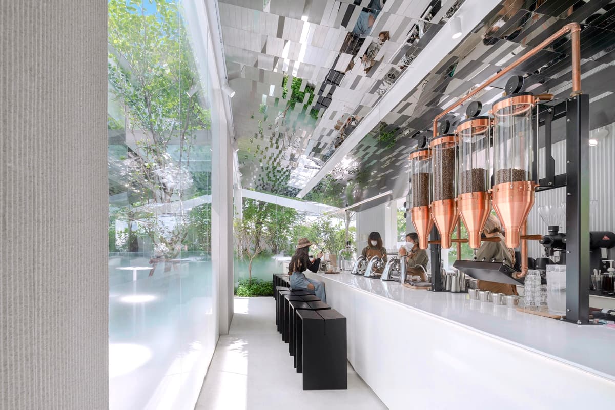 Кофейня «Nana Coffee Roasters», спроектированная бюроIDIN Architects, расположена в густонаселенном районе Бангна, Бангкок. Её основная цель — не ошеломить посетителя, а перенести его из городской суеты в спокойное и гармоничное пространство, где в центре внимания оказываются природа и сам кофе. Кофейня «Nana Coffee Roasters», спроектированная бюроIDIN Architects, расположена в густонаселенном районе Бангна, Бангкок. Её основная цель — не ошеломить посетителя, а перенести его из городской суеты в спокойное и гармоничное пространство, где в центре внимания оказываются природа и сам кофе.