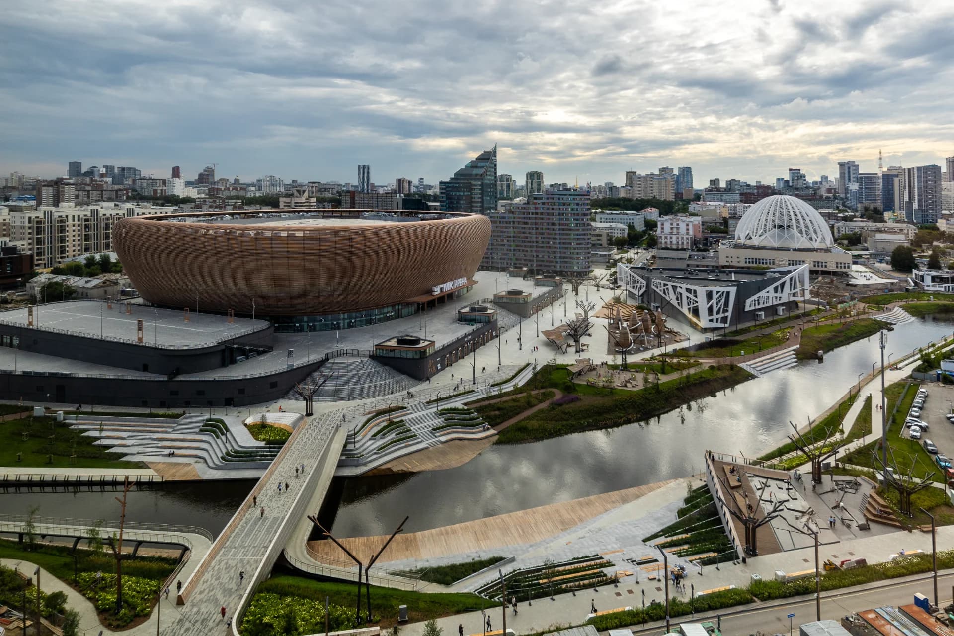 Фотография реализованного проекта набережной у Ледовой арены в Екатеринбурге, Россия. Проект выполнен S&P Landscape Architecture. Справка редакции: УГМК-Арена — масштабный спортивно-развлекательный кластер в Екатеринбурге. Проект потребовал сложнейшей инженерии для интеграции парковой зоны, водоемов и пешеходных мостов в активную общественную ткань города. Фото предоставлено S&P Landscape Architecture. Фотография реализованного проекта набережной у Ледовой арены в Екатеринбурге, Россия. Проект выполнен S&P Landscape Architecture. Справка редакции: УГМК-Арена — масштабный спортивно-развлекательный кластер в Екатеринбурге. Проект потребовал сложнейшей инженерии для интеграции парковой зоны, водоемов и пешеходных мостов в активную общественную ткань города. Фото предоставлено S&P Landscape Architecture.
