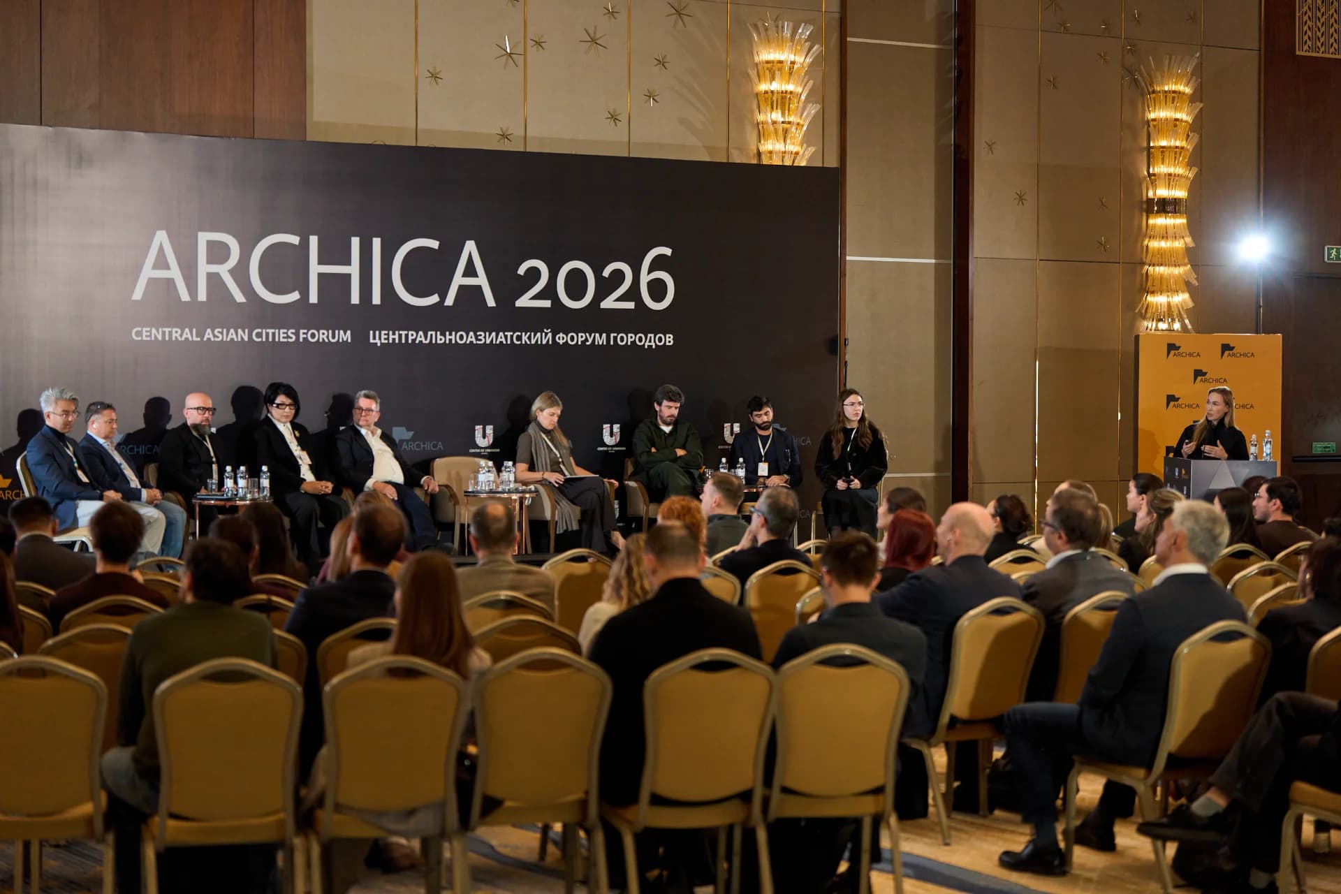Выступление основателя MAD Architects Марии Николаевой (за трибуной) на сессии Case study & Discussion. В президиуме: Алишер Сакипов (Saraiva + Associados), Хуссам Шакхуф (Metaform), Гульмира Урбиссинова (MIHON Design), Марк Аткинсон (Foster + Partners), Дуарте Лобо Антунеш (A for Architecture), Федерико Макки (SPERI) и модератор Ксения Шилкова (IND). Фото: Adil Abiltayev / ARCHICA 2026 Выступление основателя MAD Architects Марии Николаевой (за трибуной) на сессии Case study & Discussion. В президиуме: Алишер Сакипов (Saraiva + Associados), Хуссам Шакхуф (Metaform), Гульмира Урбиссинова (MIHON Design), Марк Аткинсон (Foster + Partners), Дуарте Лобо Антунеш (A for Architecture), Федерико Макки (SPERI) и модератор Ксения Шилкова (IND). Фото: Adil Abiltayev / ARCHICA 2026